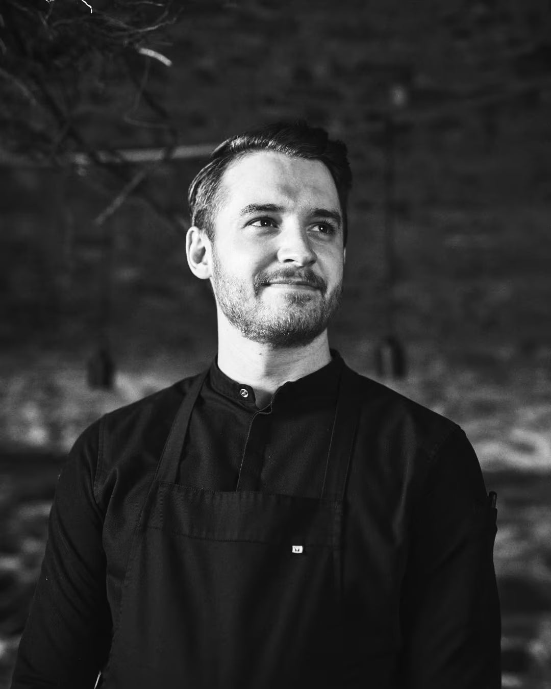 Black-and-white portrait of chef Anthony Vien in chef's whites and apron