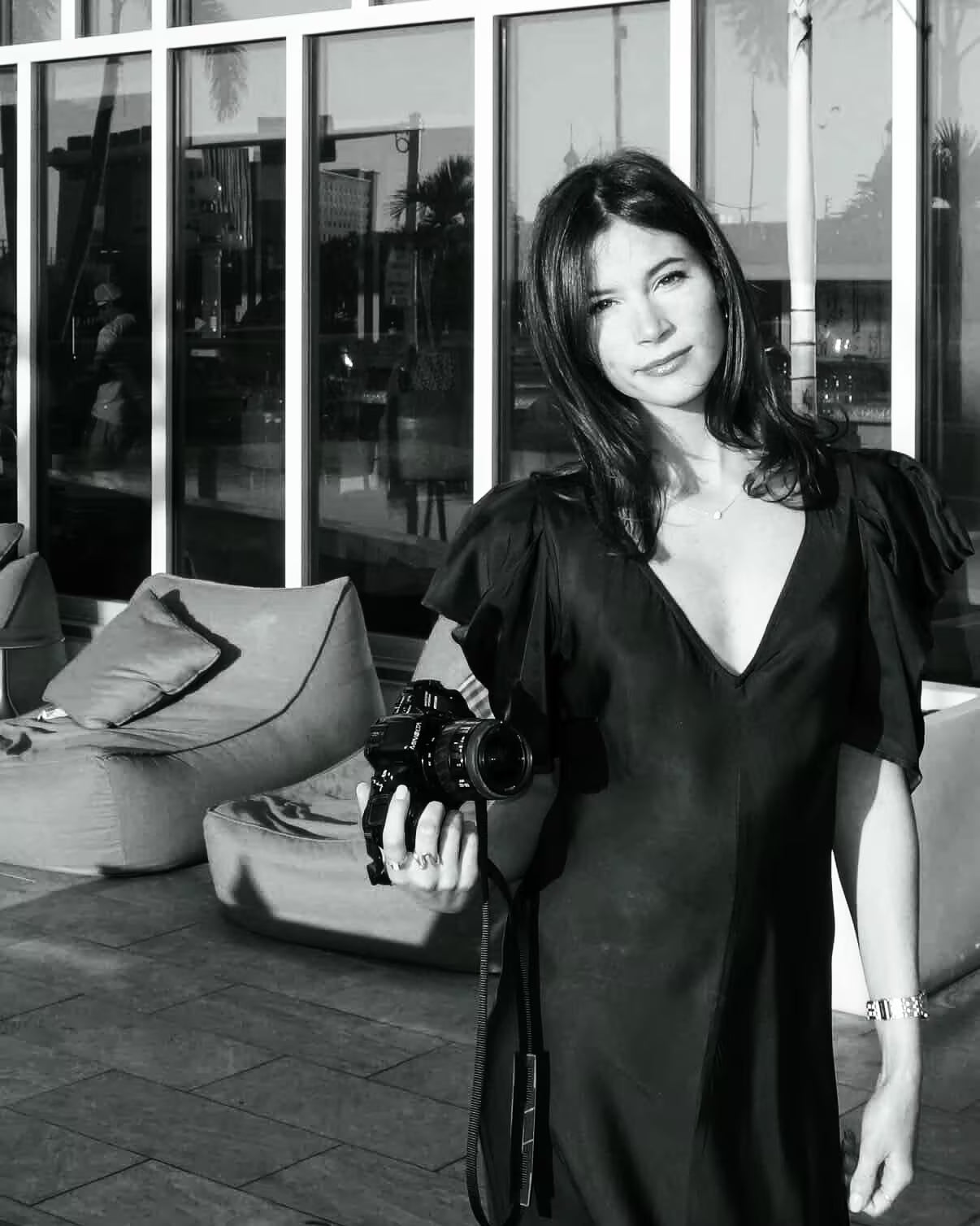 Black-and-white portrait of chef Sophia Piron holding a film camera
