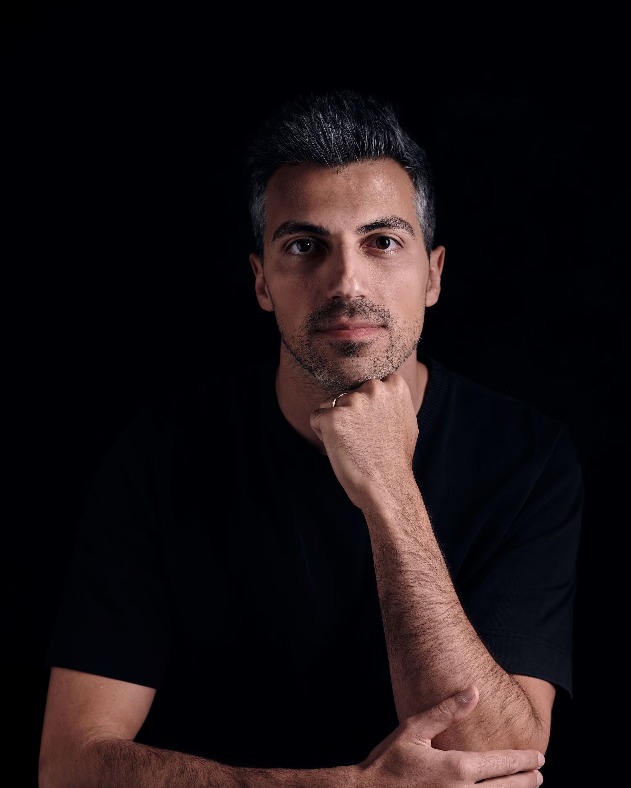 Chris Liverani, founder of Maison Liverani, in a moody studio portrait against a black background