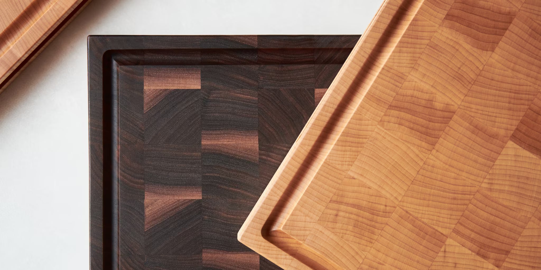 Maison Liverani end-grain cutting boards in walnut and maple shown side by side