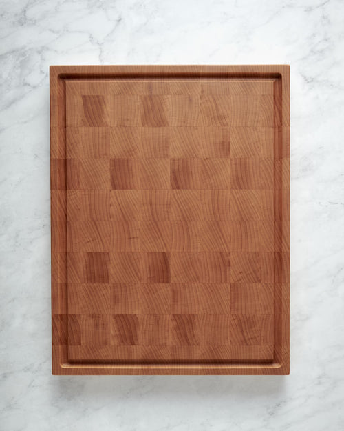 Maison Liverani maple end-grain cutting board showing juice groove side on marble surface