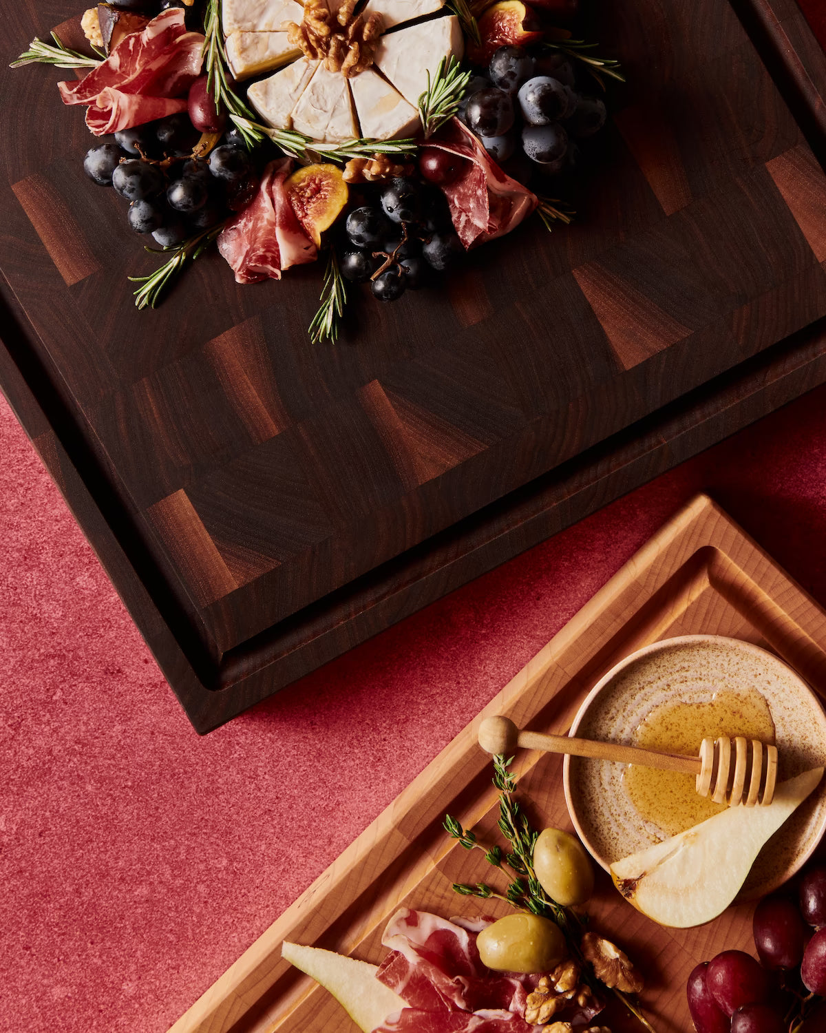 Maple and walnut Maison Liverani cutting boards styled with charcuterie on a deep red velvet background