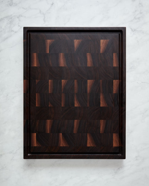 Maison Liverani walnut end-grain cutting board showing juice groove side on marble countertop